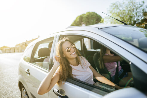 Happy friends in car seen from outside - KIJF01593