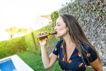 Young woman drinking beer at the poolside - KIJF01618