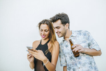 Junges Paar mit Bier und Mobiltelefon im Freien - KIJF01621