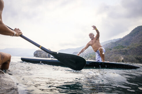 Mexiko, Banderas Bay, Los Arcos National Marine Park, Mann fällt vom Paddleboard - ABAF02166