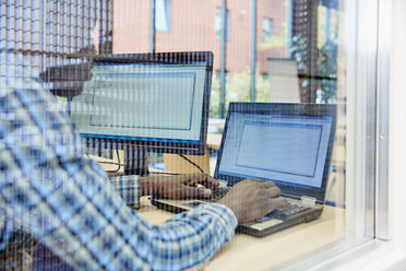 Mann benutzt Laptop im Büro - RHF01925