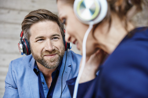 Mann und Frau hören Musik mit Kopfhörern, lizenzfreies Stockfoto