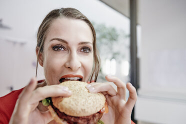 Woman eating a vegan hamburger - RHF01976