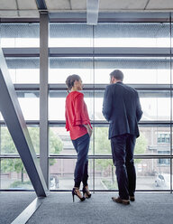 Businessman and businesswoman talking at the window - RHF02004