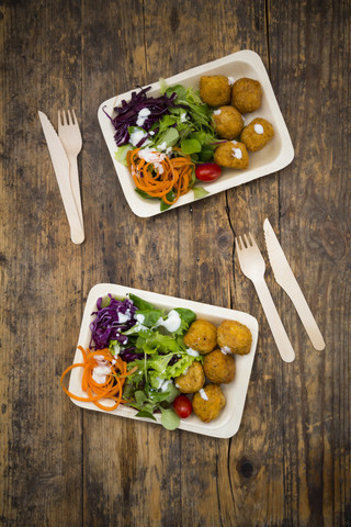 Falafel and salad on wooden disposable plates and cutlery stock photo