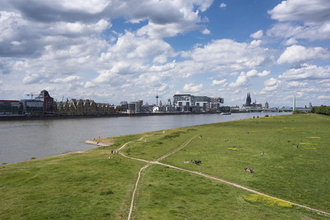 Germany, Cologne, people sunbathing on grass at Rhine harbor stock photo