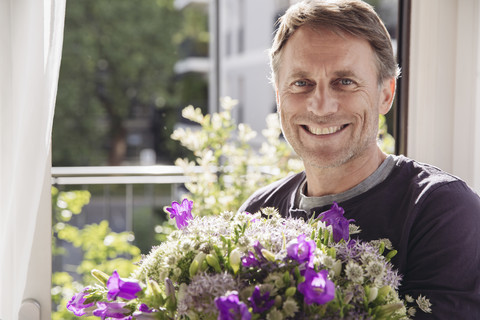 Portrait of smiling man with bunch of flowers stock photo
