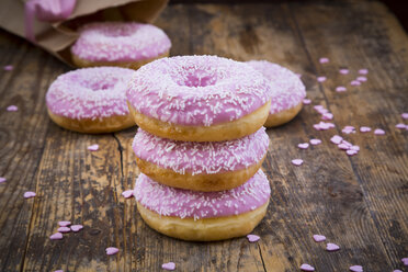 Stack of Doughnuts with pink icing and sugar granules on wood - LVF06173