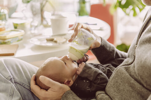 Vater füttert sein neugeborenes Baby mit der Flasche - MFF03659