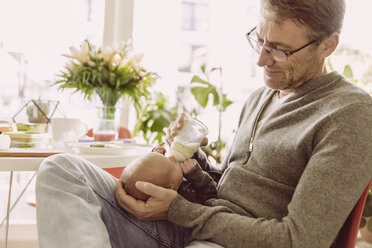 Father bottle-feeding his newborn baby boy at home - MFF03660