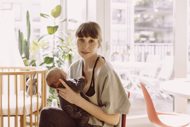 Mother holding her newborn baby boy at home - MFF03665