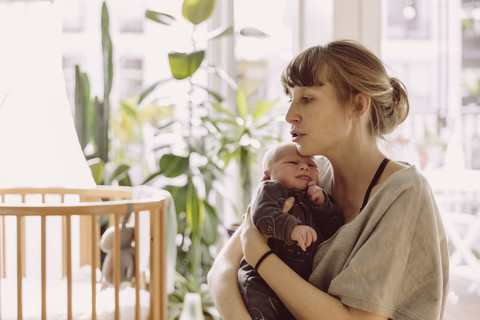 Mutter beruhigt und tröstet ihr neugeborenes Baby zu Hause, lizenzfreies Stockfoto