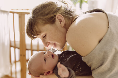 Mutter lächelt ihr neugeborenes Baby zu Hause an - MFF03667