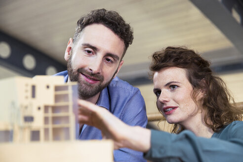 Mann und Frau diskutieren über ein Architekturmodell im Büro - FKF02357