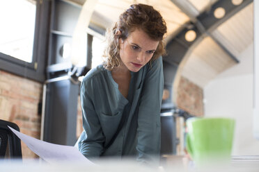 Young woman working at desk in modern office - FKF02385