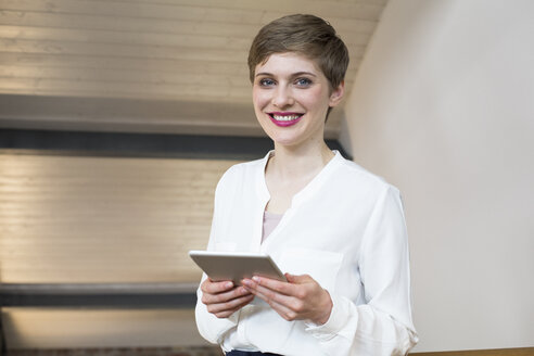 Porträt einer lächelnden Geschäftsfrau, die eine Tafel hält - FKF02392