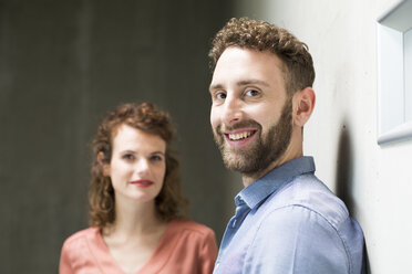 Portrait of smiling man with woman in background - FKF02408