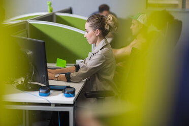 Junge Frau arbeitet am Computer in einer Bürozelle - ZEF14039