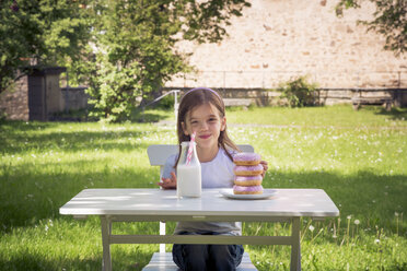 Girl with stack of donuts on garden table - LVF06192