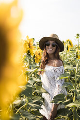 Glückliche Frau in einem Sonnenblumenfeld - MAUF01074