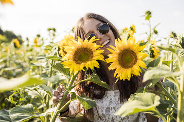 Glückliche Frau in einem Sonnenblumenfeld - MAUF01075