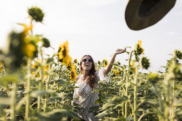 Glückliche Frau in einem Sonnenblumenfeld - MAUF01076
