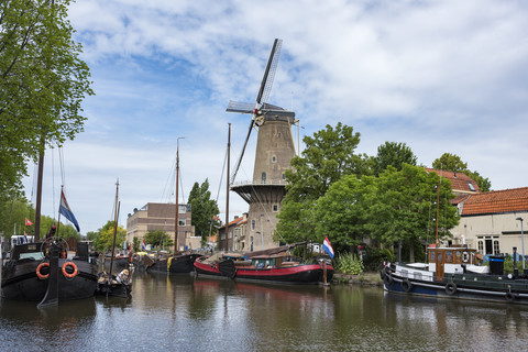 Netherlands, Gouda, harbor with traditional sailing ships and wind mill stock photo