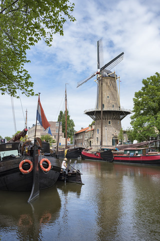 Netherlands, Gouda, harbor with traditional sailing ships and wind mill stock photo