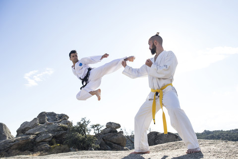 Man doing a jump kick during a martial arts combat stock photo