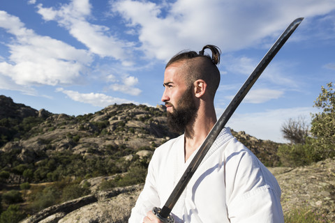 Mann hält ein Katana-Schwert, lizenzfreies Stockfoto