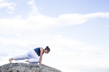 Frau bei einer Yoga-Übung auf einem Felsen - ABZF02131