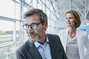 Smiling businessman and businesswoman at the airport - RORF00944