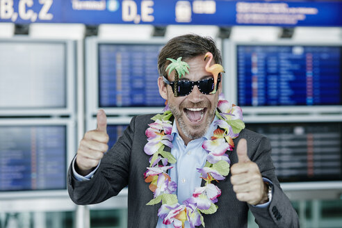 Happy businessman dressed up as tourist at the airport - RORF00951