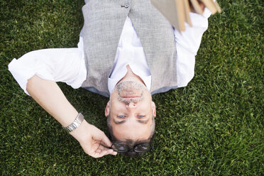 Mature businessman lying on grass - HAPF01741