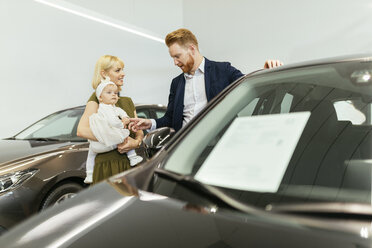 Family in car dealership choosing family vehicle - ZEDF00667