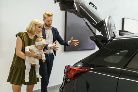 Familie im Autohaus bei der Auswahl des Familienfahrzeugs, lizenzfreies Stockfoto