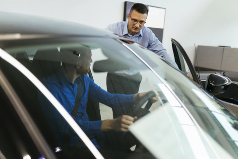 Salesman explaining car to customer stock photo