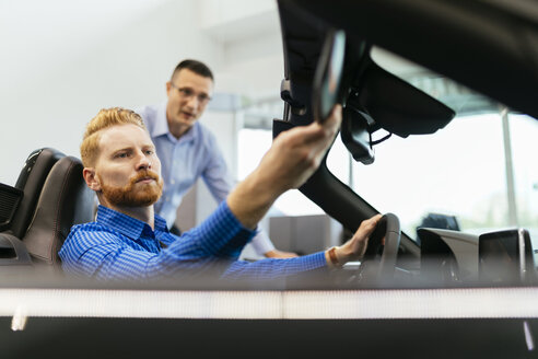 Kunde im Autohaus, der ein Fahrzeug testet - ZEDF00684