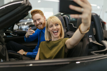 Pärchen macht Selfies, sitzt im Cabrio im Autohaus - ZEDF00691