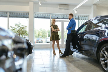 Couple looking for a new car in car dealership - ZEDF00698
