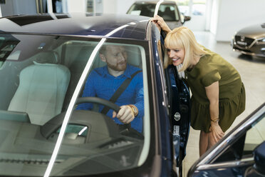 Couple looking for a new car in car dealership - ZEDF00702