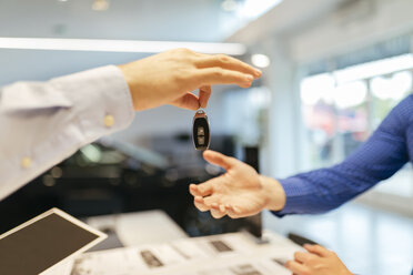 Verkäufer bei der Übergabe der Autoschlüssel an den Kunden - ZEDF00708