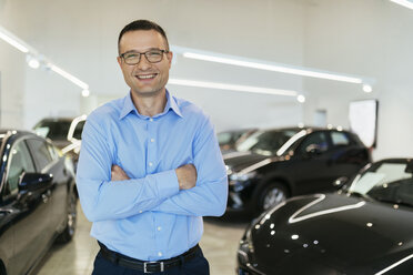 Car dealer standing in his shop - ZEDF00711