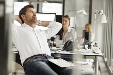 Businessman relaxing at desk in office - PESF00699