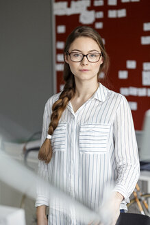 Porträt einer selbstbewussten jungen Frau in einem Büro vor einem Scrum Board - PESF00720
