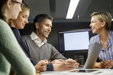 Colleagues with laptop having a meeting in meeting box - PESF00735