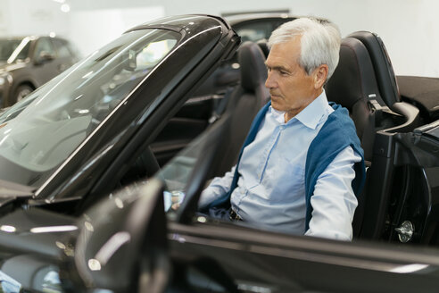 Älterer Mann testet Cabrio im Autohaus - ZEDF00716