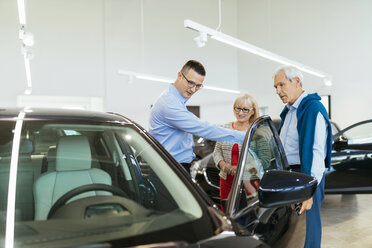 Älteres Ehepaar im Gespräch mit einem Verkäufer in einem Autohaus - ZEDF00725