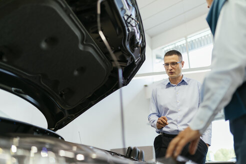 Verkäufer, der einen Kunden im Autohaus berät - ZEDF00737