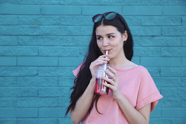 Portrait of young woman drinking soft drink - RTBF00922